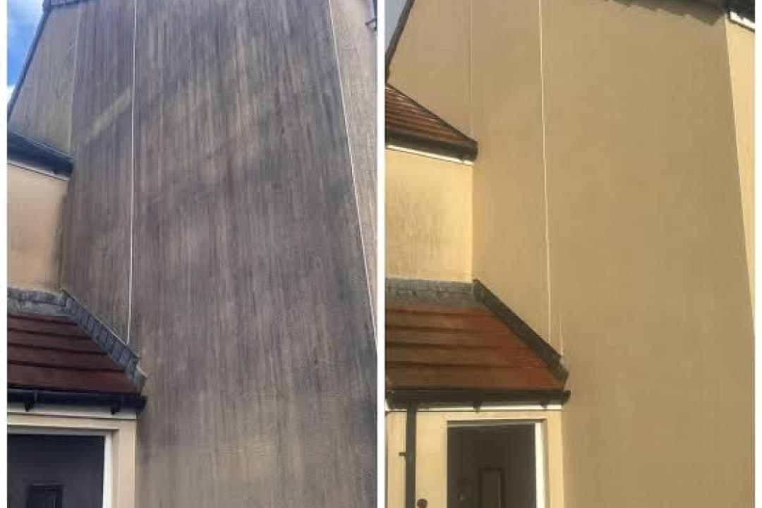 A tall stretch of streaked render beside the same wall washed clean
