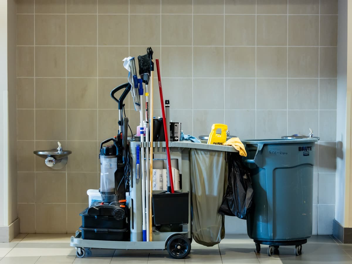 A fully stocked Jodh Building Services janitorial cart in a commercial building